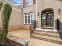 Brick home featuring a well-kept front lawn, brick entrance steps, and black railing at 9220 Meadow Mist Ct, Raleigh, NC 27617