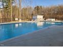 Community pool with chairs, a fence, and a no lifeguard on duty sign at 100 Slippery Elm Rd, Youngsville, NC 27596