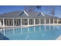 Relaxing view of a community swimming pool with blue lounge chairs and a lovely building nearby at 100 Slippery Elm Rd, Youngsville, NC 27596