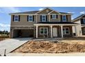 Two-story home featuring stone accents, vertical siding, an attached two-car garage, and a covered front porch at 107 Southern Estates Dr, Sanford, NC 27330