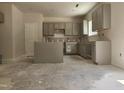 The new kitchen featuring sleek grey cabinets and a central island, awaiting countertops and appliances at 143 Mildred Place, Broadway, NC 27505