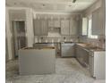 Unfinished kitchen featuring gray cabinets and a kitchen island awaiting completion at 143 Mildred Place, Broadway, NC 27505