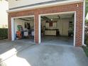 Spacious two-car garage with brick exterior and ample storage space, perfect for organization and convenience at 1613 Beacon Valley Dr, Raleigh, NC 27604