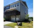 Desirable townhome featuring a spacious deck with flower boxes above a convenient two-car garage and driveway at 1643 Wimberly Rd, Apex, NC 27523