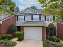 Street view of a two-story townhome with an attached garage and well-maintained front yard at 2067 White Pond Ct, Apex, NC 27523