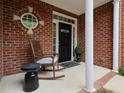 Cozy front porch featuring a rocking chair, decorative brickwork, and a welcoming entrance at 2067 White Pond Ct, Apex, NC 27523