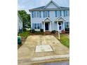 Exterior shot of a townhome featuring a front yard and a symmetrical facade with blue shutters at 2125 Ventana Ln, Raleigh, NC 27604