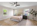 Bright bedroom features a ceiling fan, large windows and a comfortable king bed at 2304 Nelson St, Raleigh, NC 27610