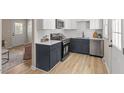 Modern kitchen with stainless steel appliances, white countertops and navy cabinets at 2304 Nelson St, Raleigh, NC 27610