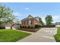 Brick home featuring a well-manicured lawn, landscaping, a driveway, and an attached garage at 2326 Marlow Dr, Burlington, NC 27215