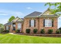 Beautiful brick home with manicured lawn, landscaping, and inviting front entrance with a pop of color at 2326 Marlow Dr, Burlington, NC 27215