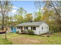 View of the side of a single-story home with chain-link fencing and mature trees at 2721 Thelma St, Durham, NC 27704