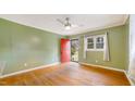 Bright living room with hardwood floors, ceiling fan, and a red front door at 2721 Thelma St, Durham, NC 27704