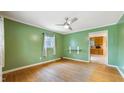 Green living room with hardwood floors, ceiling fan, and window with natural light at 2721 Thelma St, Durham, NC 27704