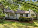 Backyard featuring a dark wood deck, well-maintained lawn, and lovely landscaping and brick and vinyl siding at 3014 Hope Valley Rd, Durham, NC 27707