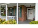 Cozy front porch with brick accents, white columns, and inviting decor at 402 Green Turret Dr, Rolesville, NC 27571