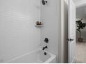 Bright bathroom showing a white tub and shower combination with black fixtures at 4504 Mint Leaf Ln, Raleigh, NC 27612
