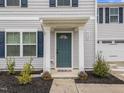 Inviting front entrance with a teal door, decorative columns, landscaping, and clear address numbers at 4524 Flat Bastion Drive Dr, Raleigh, NC 27610