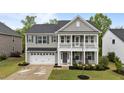 Charming two-story home with a welcoming front porch and a two-car garage, showcasing classic architectural details at 4803 Stony Falls Way, Knightdale, NC 27545