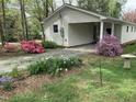 The home features a covered carport and a gravel driveway with landscaping and mature plantings at 505 E Graham St, Mebane, NC 27302