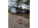 A gray house with white trim is viewed from the side with a gravel driveway at 5116 Nc 56 Hwy, Franklinton, NC 27525