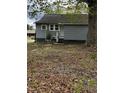The house has gray siding and a small front porch with some greenery and a tree at 5116 Nc 56 Hwy, Franklinton, NC 27525