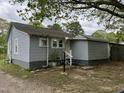 Rear exterior shot of a one-story house with a gravel driveway and fenced yard at 5116 Nc 56 Hwy, Franklinton, NC 27525
