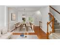 Bright dining room boasts hardwood floors, wainscoting, and a modern light fixture over the dining table at 5507 Vista View Ct, Raleigh, NC 27612