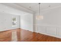 This living room is bright with hardwood floors, recessed lights, and white walls and decorative molding at 5507 Vista View Ct, Raleigh, NC 27612