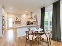 Bright kitchen and dining area with a kitchen island, stylish lighting, stainless steel appliances, and hardwood floors at 612 E Ellerbee St, Durham, NC 27704