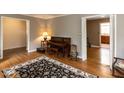 Open floor plan with hardwood floors, a piano, and views into other rooms of the home at 6813 W Lake Anne Dr, Raleigh, NC 27612