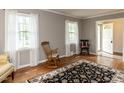 Bright living room with hardwood floors, two windows with sheer curtains, and rocking chairs to enjoy the view at 6813 W Lake Anne Dr, Raleigh, NC 27612