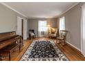 Spacious living room with hardwood floors, a piano, and plenty of seating for entertaining guests at 6813 W Lake Anne Dr, Raleigh, NC 27612