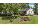Charming one-story home with a beautiful landscaped front yard and flowering trees at 700 Sawmill Rd, Raleigh, NC 27615