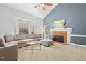 Spacious living room featuring a brick fireplace, large windows, and comfortable seating area at 7112 Benhart Dr, Raleigh, NC 27613