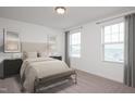 Bright bedroom featuring neutral color scheme, two windows and a carpet flooring at 817 Kenyon Springs Dr, Zebulon, NC 27597