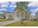 Attractive two-story home with a two-car garage, and neutral-colored siding on a manicured lawn at 82 White Ash Dr, Clayton, NC 27527