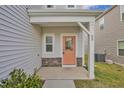 Close up of porch with stone accents, peach colored door, house number and gray siding at 82 White Ash Dr, Clayton, NC 27527