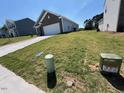 A lovely home is set on a grassy lot, blending neighborhood charm with outdoor space at 821 Kenyon Spring Dr, Zebulon, NC 27597