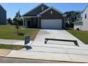Charming single-story home featuring gray siding, brick accents, a well-manicured lawn, and a two-car garage at 821 Kenyon Spring Dr, Zebulon, NC 27597