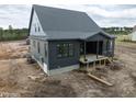 New construction home features dark siding and a partially completed back porch at 8620 Dukes Lake Rd, Zebulon, NC 27597