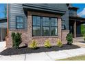 Close-up of the exterior reveals a brick base, trimmed windows and a well-manicured landscape at 8620 Dukes Lake Rd, Zebulon, NC 27597