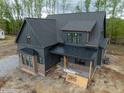 New construction home features dark siding, copper gutters and a brick foundation at 8620 Dukes Lake Rd, Zebulon, NC 27597