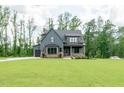 Beautiful craftsman-style home with gray siding, brick accents, copper gutters, and a well-manicured lawn at 8620 Dukes Lake Rd, Zebulon, NC 27597