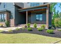 Charming front porch with wood columns and brick accents, enhanced by professional landscaping at 8620 Dukes Lake Rd, Zebulon, NC 27597