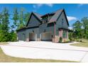 Spacious three-car garage with a long driveway and a partial view of the home's exterior at 8620 Dukes Lake Rd, Zebulon, NC 27597