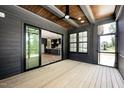 Covered porch with a wood ceiling and view of the kitchen through the sliding door at 8620 Dukes Lake Rd, Zebulon, NC 27597
