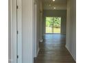 Inviting hallway featuring wood-look floors leading to a sunlit room with sliding glass doors at 89 Grove Township Way, Angier, NC 27501