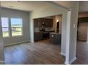 Open kitchen with granite countertops, stainless steel appliances, and wood-look flooring at 89 Grove Township Way, Angier, NC 27501
