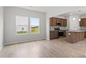 Open-concept kitchen with dark cabinets, granite countertops, stainless steel appliances, and hardwood floors at 89 Grove Township Way, Angier, NC 27501